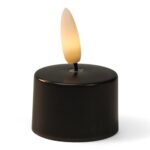 Ett litet svart LED-värmeljus med plastlåga som avger ett varmt, gulaktigt sken.