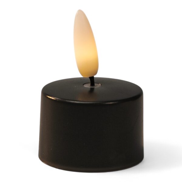 Ett litet svart LED-värmeljus med plastlåga som avger ett varmt, gulaktigt sken.